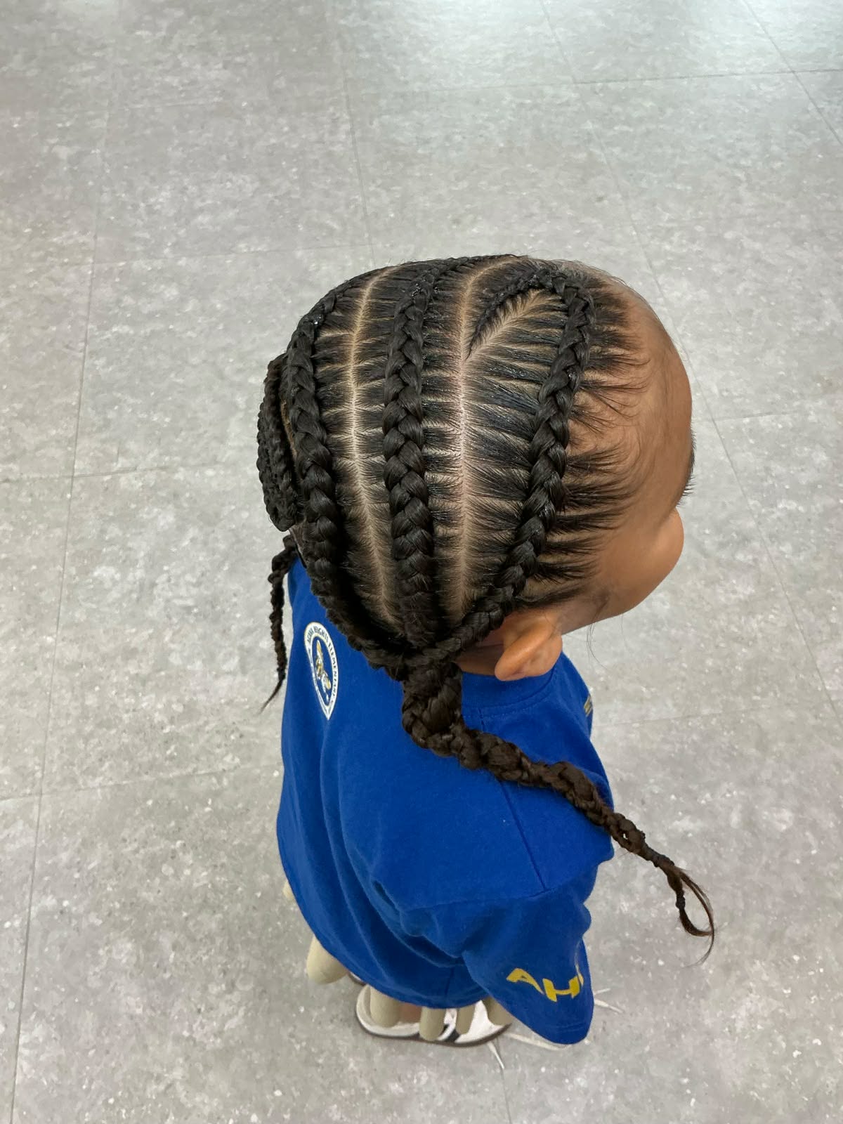 Stitch cornrows with a heart parting on a toddler
