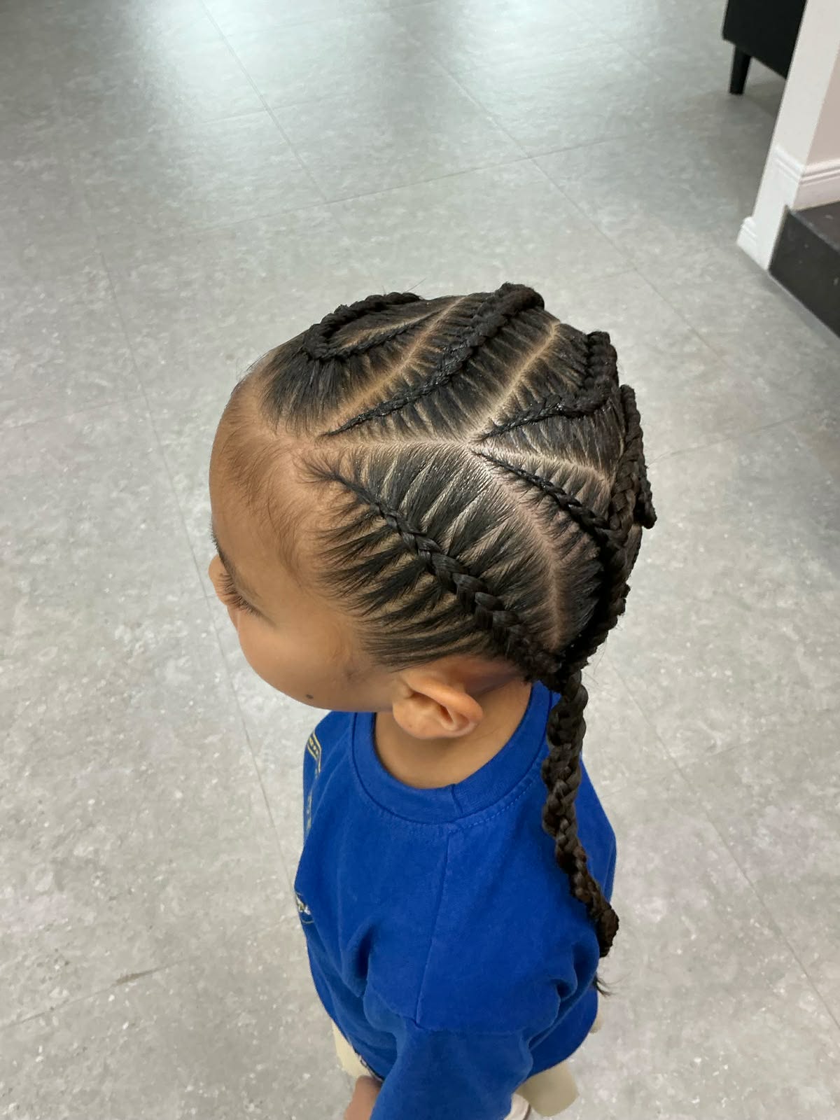 Feed-in cornrows in a zigzag pattern on a young client