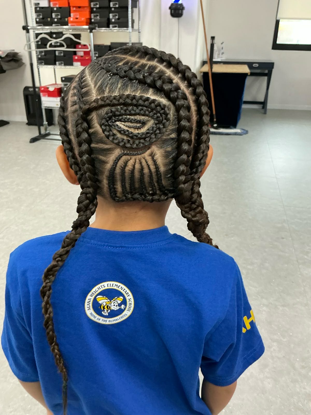 Cornrows finished in a spiral crown design on a child