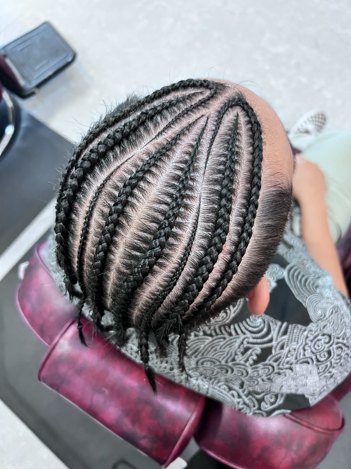 Slim curved cornrows on a male client